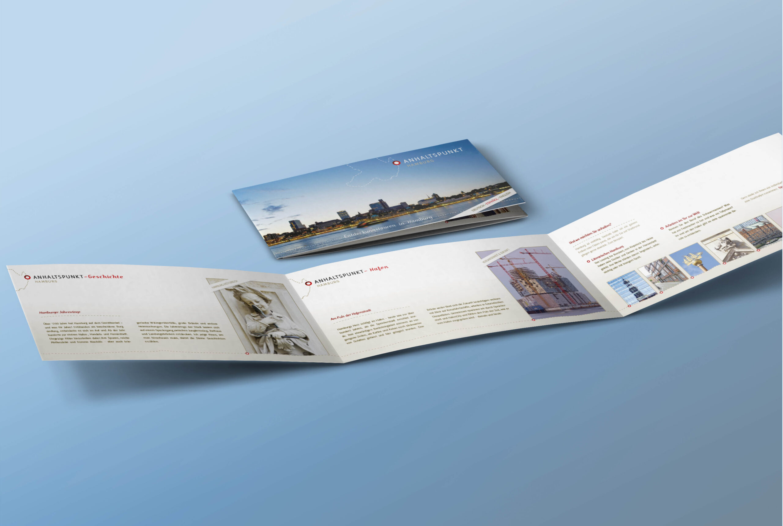 Anhaltspunkt Hamburg – Flyer und Broschüre Aufgeklappter Flyer und Broschüre im Corporate Design von Anhaltspunkt Hamburg mit Stadtmotiv und klarer Struktur auf blauem Hintergrund.