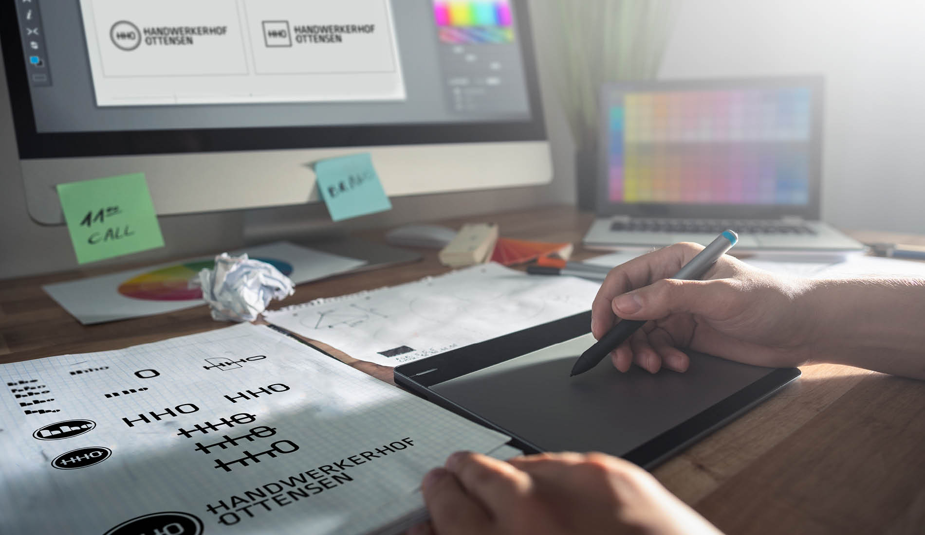 Designer arbeitet an einem Logokonzept für den Handwerkerhof Ottensen auf einem Grafiktablett am Schreibtisch.