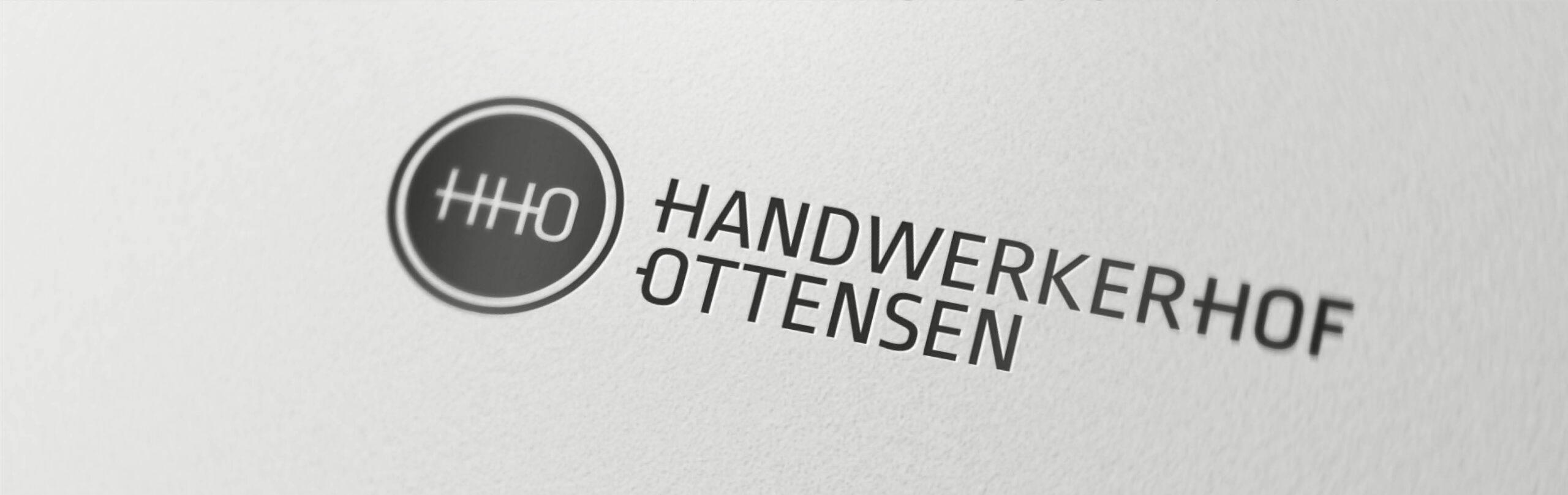 Logo des Handwerkerhof Ottensen mit kreisförmigem Symbol und moderner Schrift auf weißem Hintergrund.