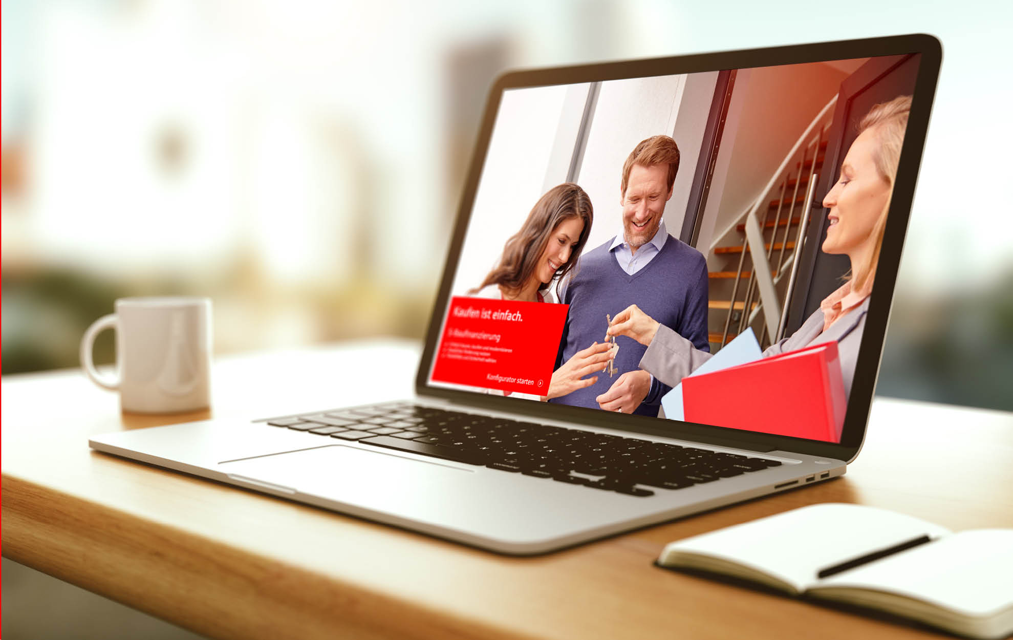 Laptop auf einem Schreibtisch mit geöffneter Website der Sparkasse, die eine Baufinanzierung mit dem Slogan „Kaufen ist einfach“ zeigt.