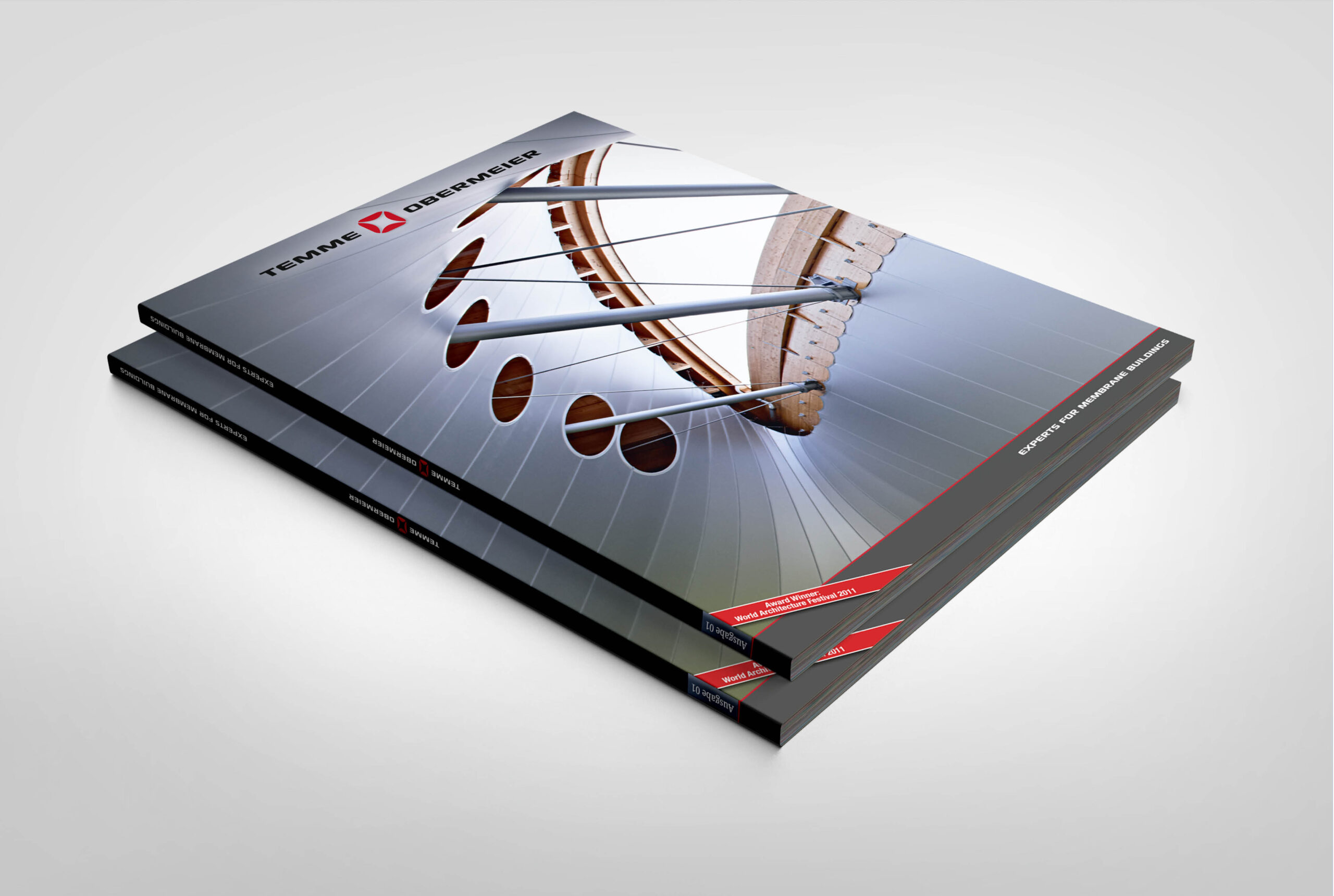 Gestapelte Broschüren im Corporate Design von Temme Obermeier mit Architekturmotiv und technischer Strukturaufnahme.