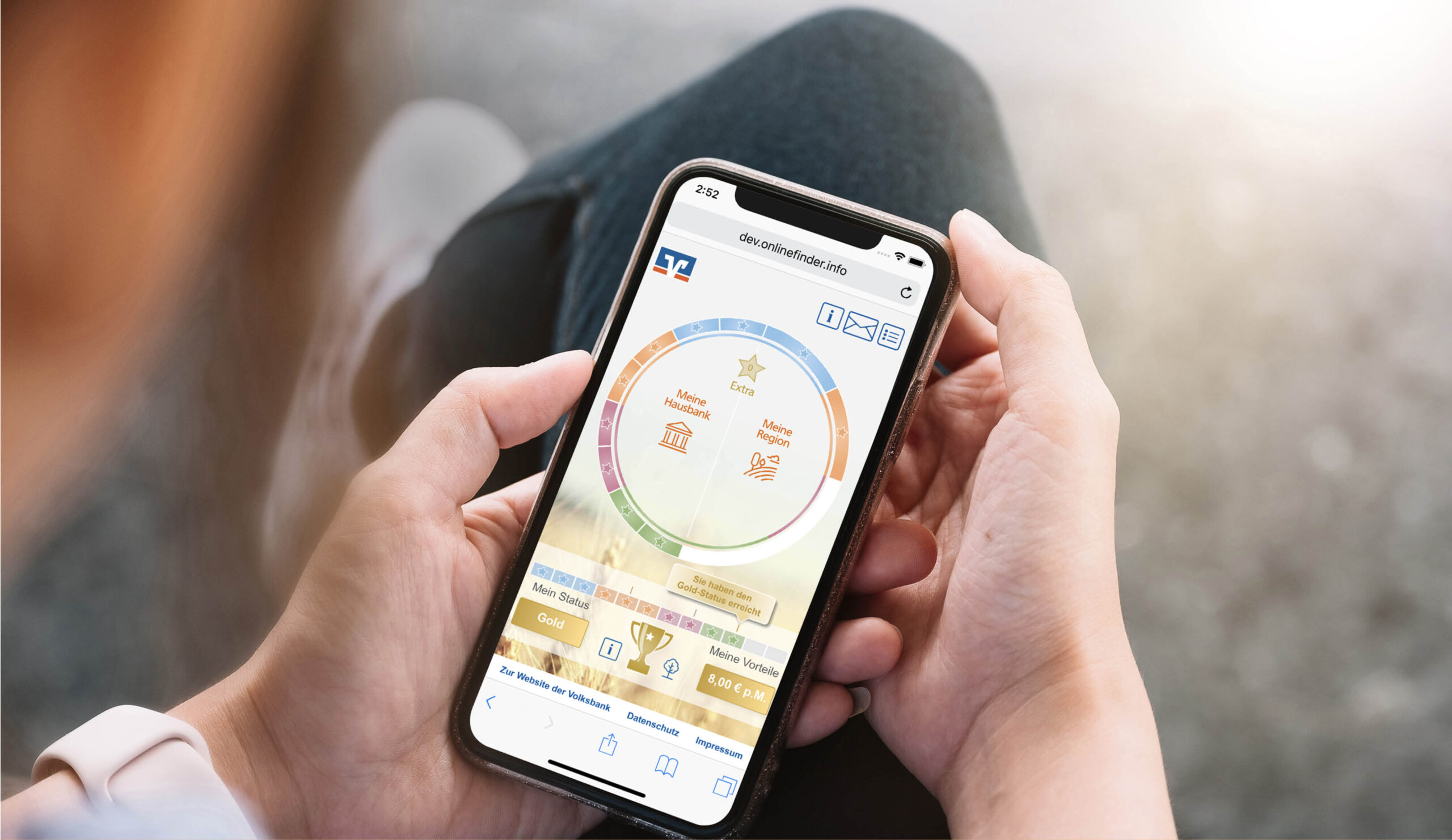 Person hält ein Smartphone mit dem Volksbank Hausbank-Vorteil-Tool, das den persönlichen Status und Bonus im Kreisdiagramm anzeigt.