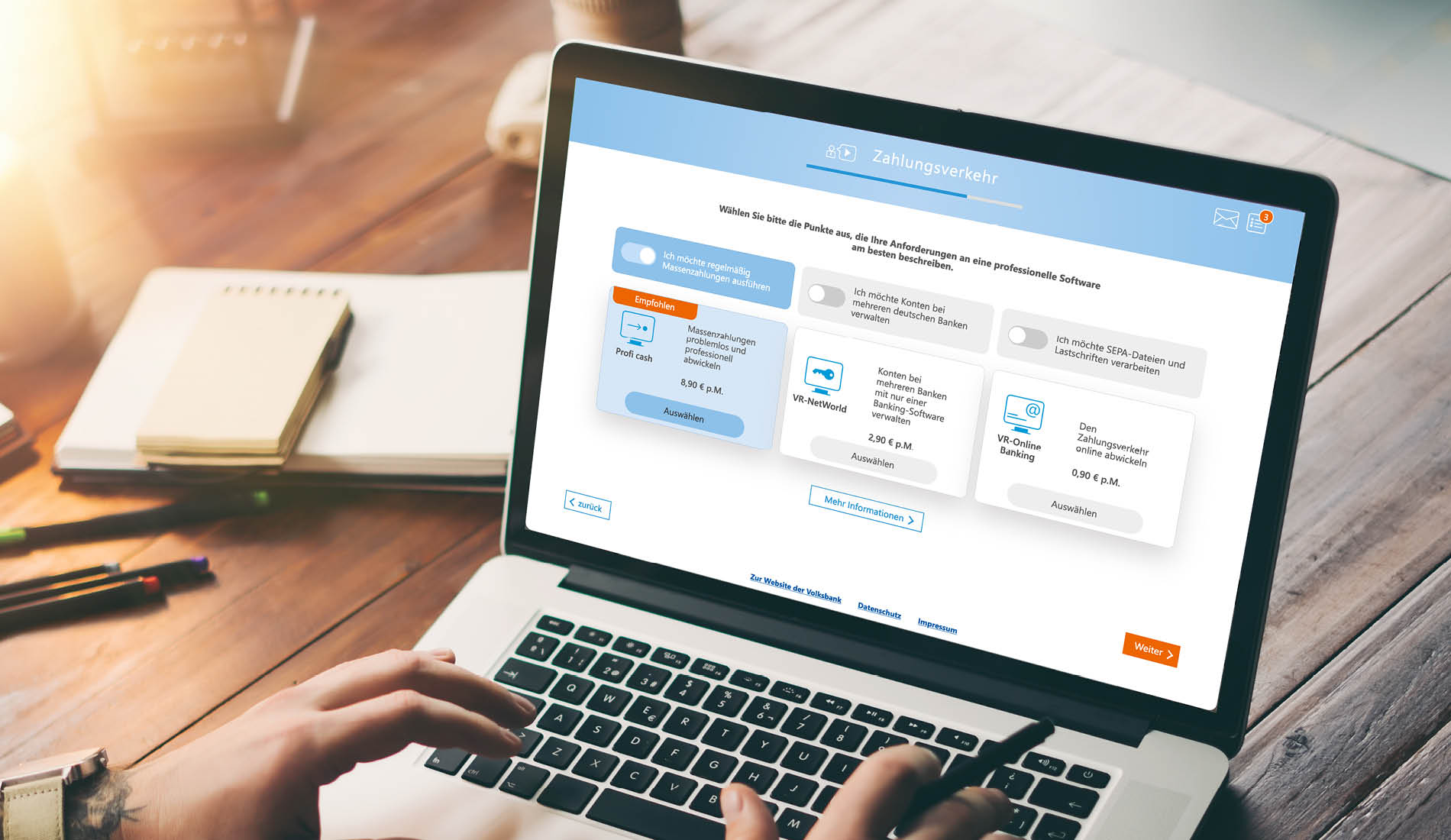 Person arbeitet am Laptop mit einer interaktiven Webapplikation für Zahlungsverkehr auf der Website einer Volksbank.