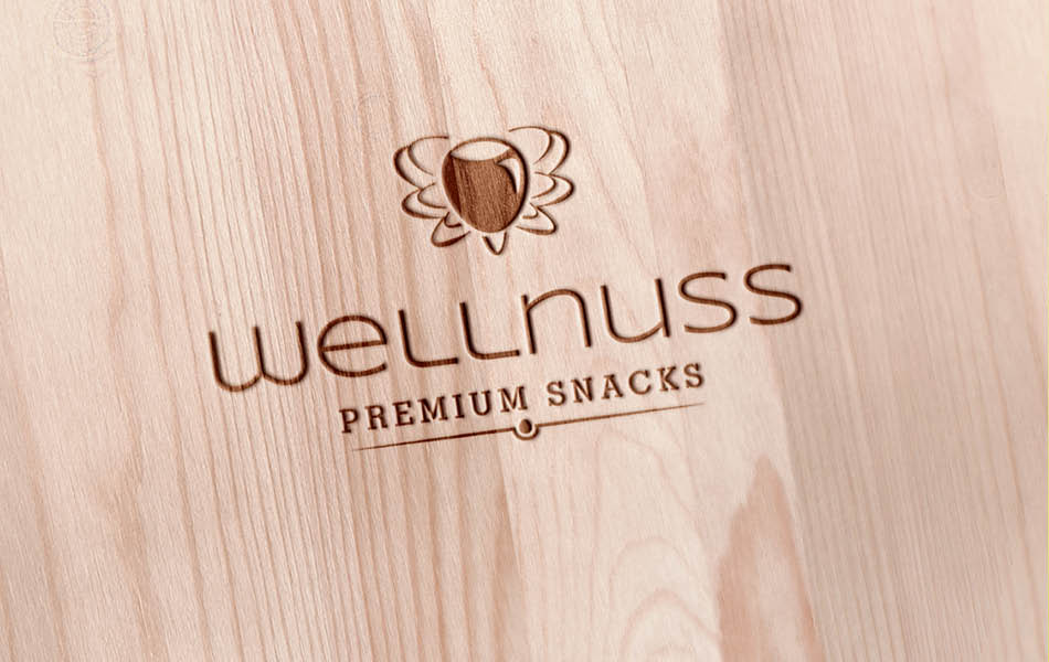 Wellnuss Logo als Holzprägung – edles Branding-Design mit natürlicher Materialanmutung für Premium Snacks.